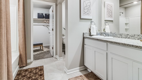 Primary bathroom with granite countertop and tile floors