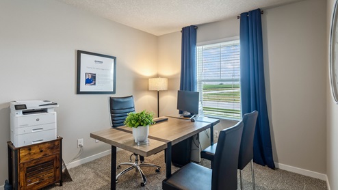 Fourth bedroom staged as an office with desk and chairs