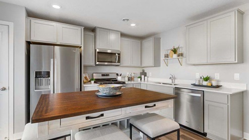 Kitchen with stainless appliances and quartz countertops.