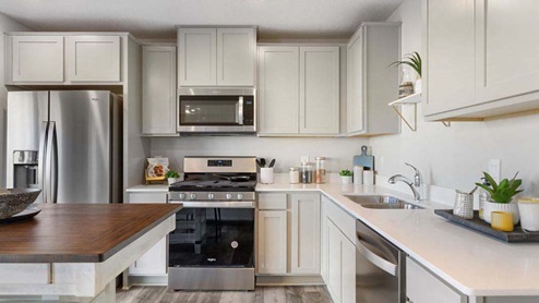 Kitchen with stainless appliances and quartz countertops.