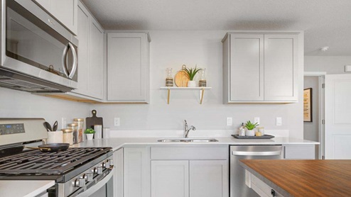Kitchen with stainless appliances and quartz countertops.